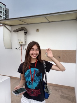Joven inquilina mostrando sus llaves en la azotea del edificio